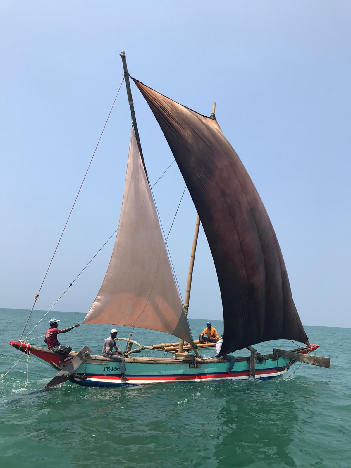 Guests seated on oruwa outrigger as local crew prepares to launch the boat into the surf